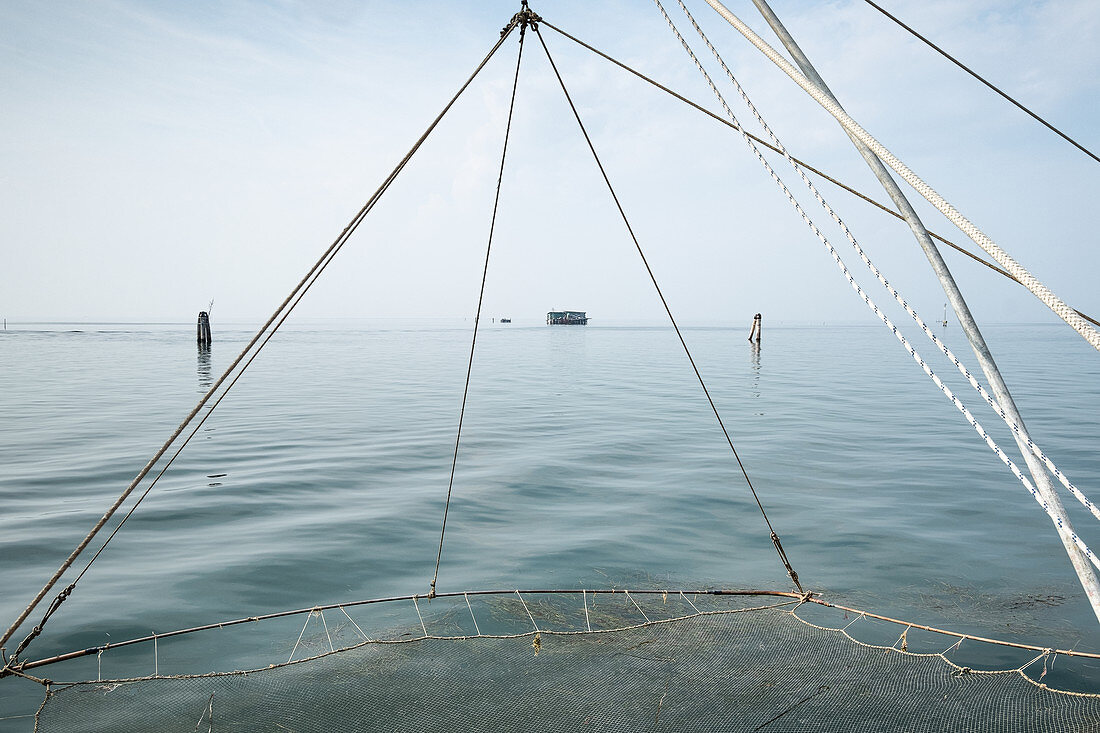 Blick auf ein Stelzenhaus, im Vordergrund ein Fischernetz, Hafen von Pellestrina, Lagune von Venedig, Venetien, Italien, Europa
