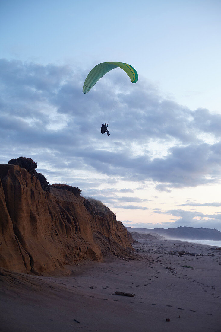 Paraglider pilots at sunset on Point Reyes Beach, California, USA.