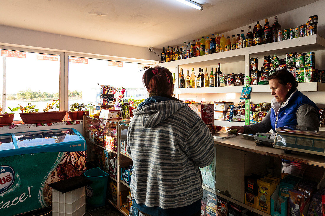 Village shop in the Danube Delta, customer and saleswoman, Mila 23, Tulcea, Romania.