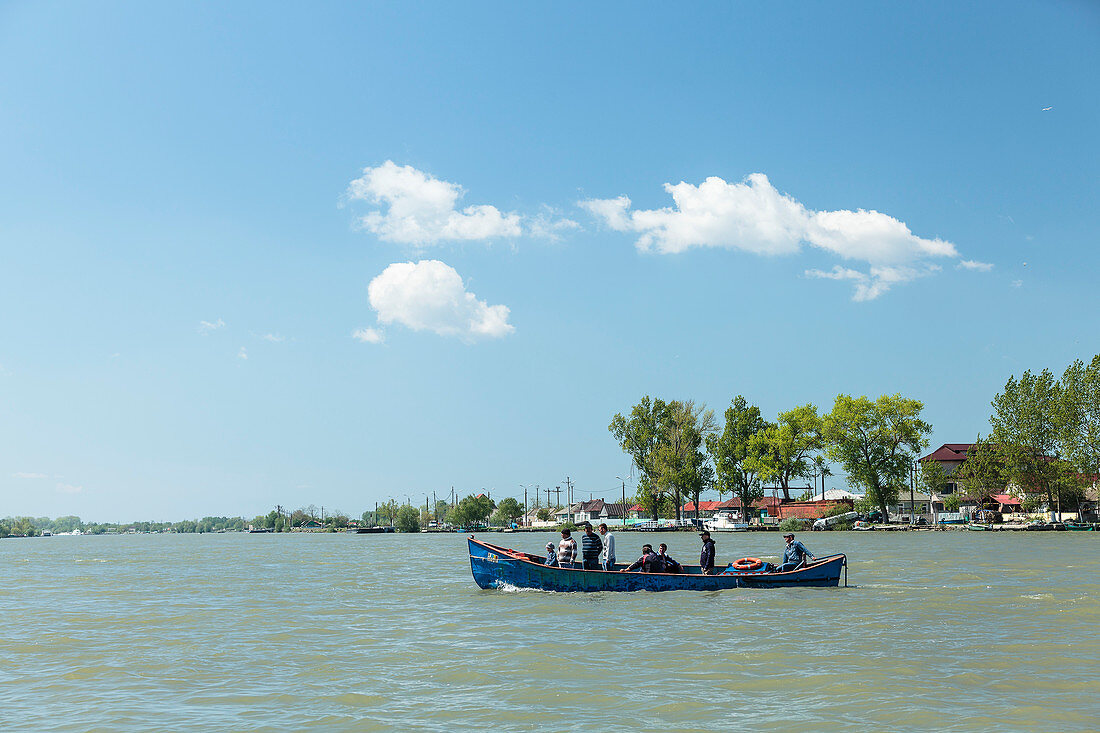 Danube Delta, a boat sets off over the Sulina arm, Sulina, Tulcea, Romania.
