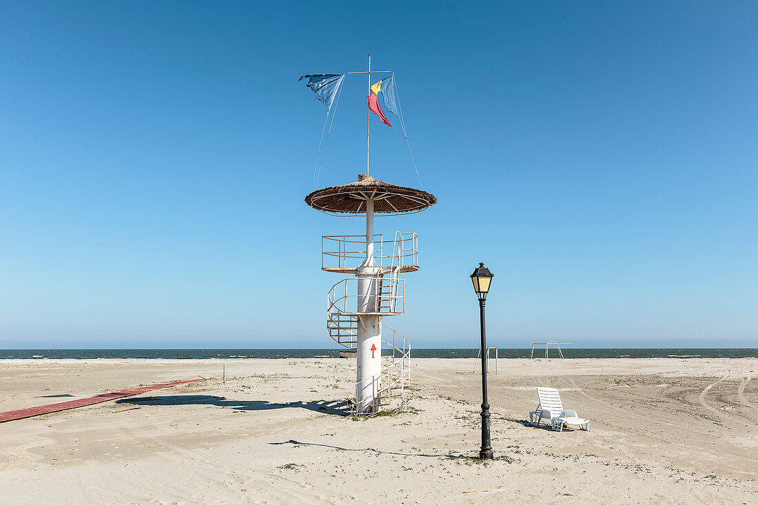 Schwarzmeerküste bei Donaumündung, Donaudelta, Aussichtsturm, Laterne und Liege im Sand, Sulina, Tulcea, Rumänien.