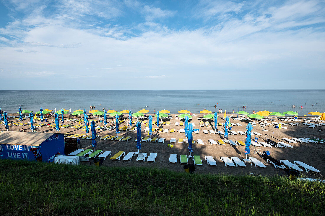 Schwarzmeerküste: Liegen und Sonnenschirme am Strand, Olimp, Kreis Constanta, Rumänien.