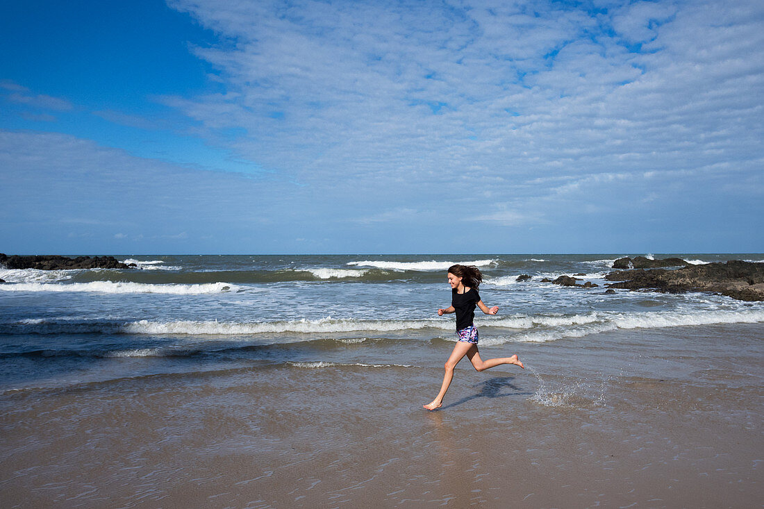 Young woman running on Havaisinho Beach near Itacaré, Bahia, Brazil, South America