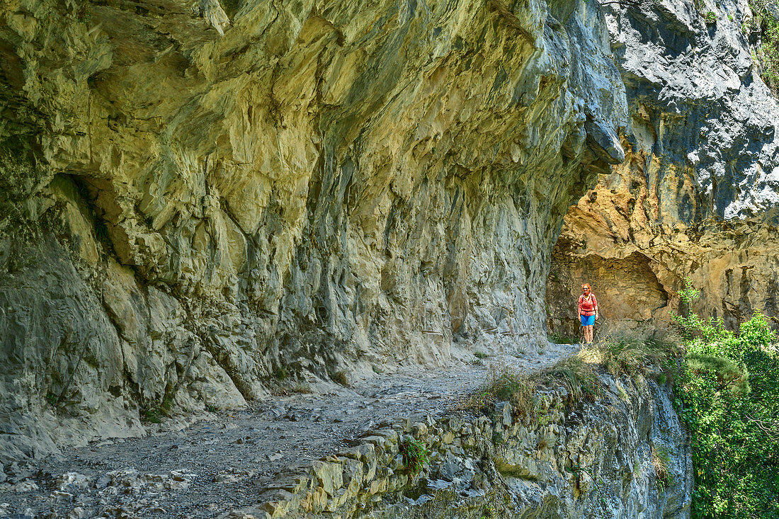 Woman hiking through the Ruta del Cares gorge, Cares Gorge, Picos de Europa, Picos de Europa National Park, Cantabrian Mountains, Asturias, Spain