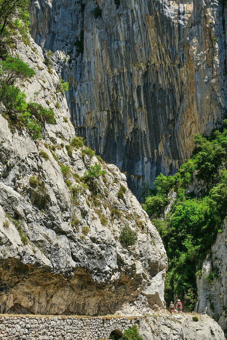 Zwei Personen beim Wandern durch die Schlucht Ruta del Cares, Caresschlucht, Nationalpark Picos de Europa, Kantabrisches Gebirge, Asturien, Spanien