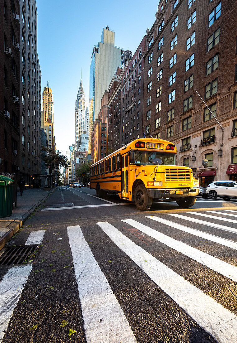 Gelber Schulbus unter Chrisler Building. Manhattan, New York, USA