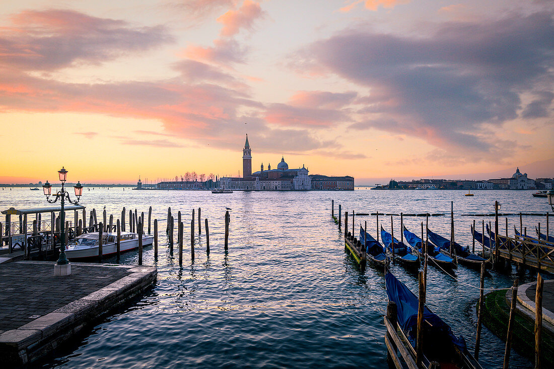 Gondolas near St Mark Square with San Giorgio Island on the background during sunrise. Venice, Veneto, Italy.