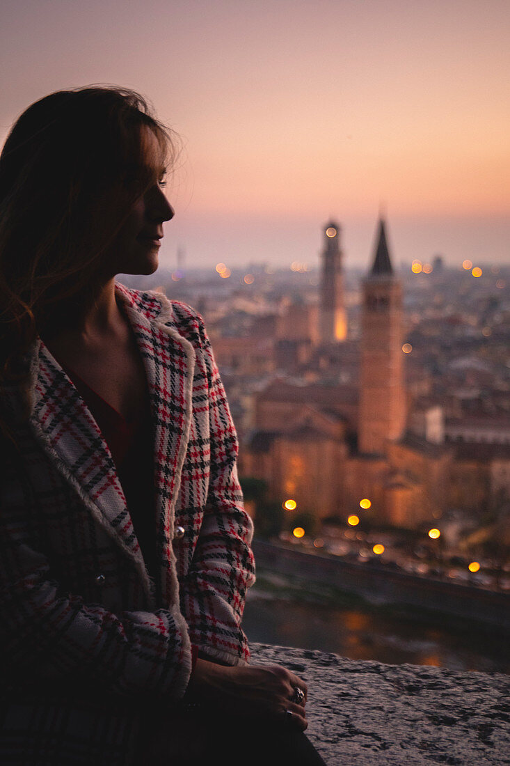 A girl looking at Verona city during sunset. Verona, Veneto, Italy