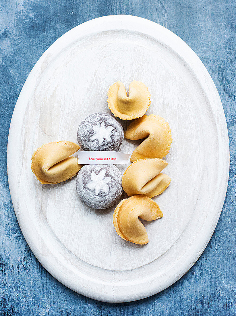 Oval dish of Fortune Cookies and small cakes.