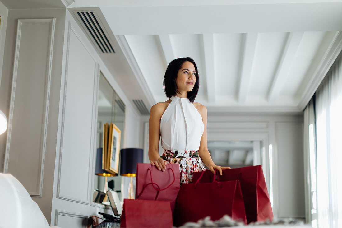 Fashionable woman with shopping bags in suite