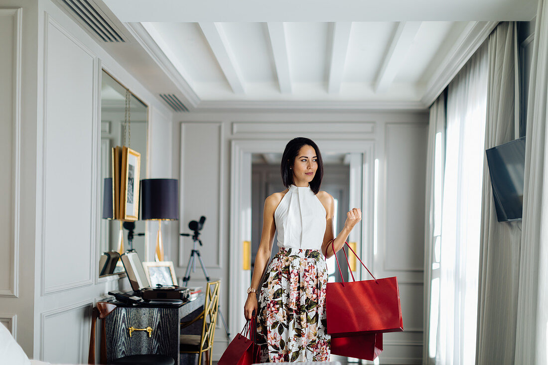 Fashionable woman with shopping bags in suite