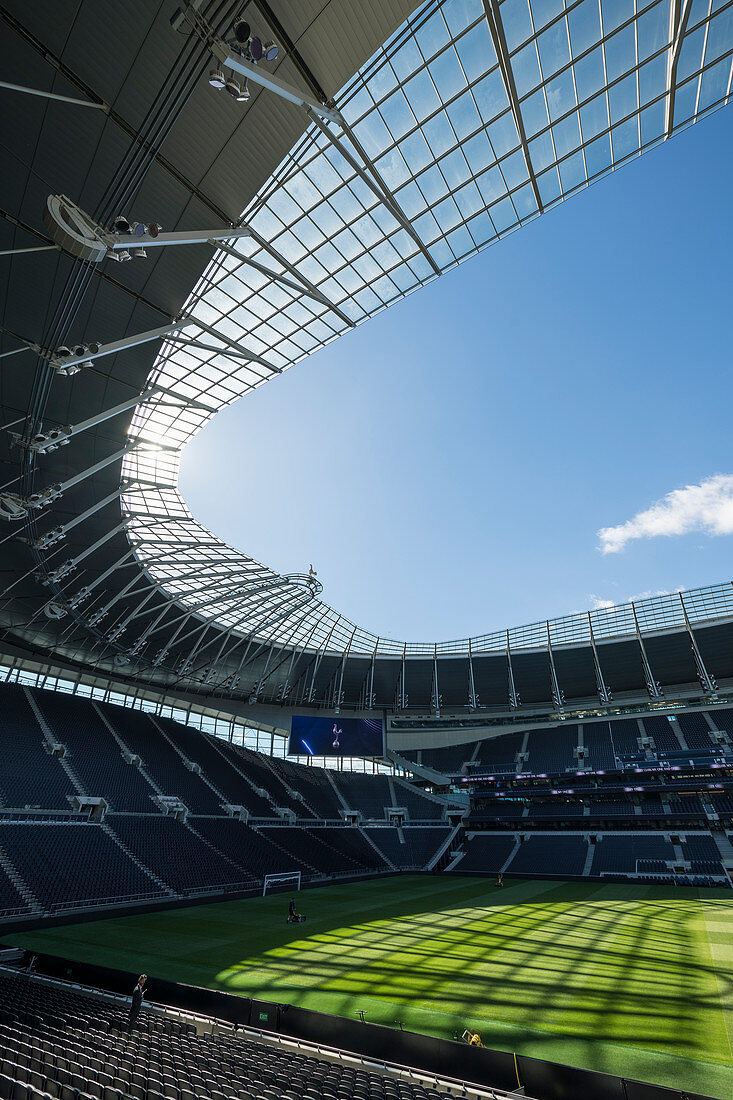 Tottenham Hotspur football stadium, empty stands and sunshine on the pitch.