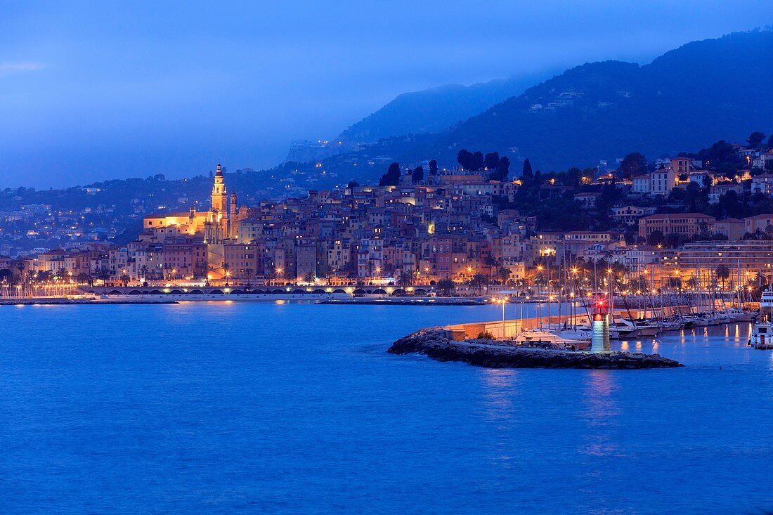 France, Alpes Maritimes, Menton, lighthouse of the port of Garavan, the old town in background