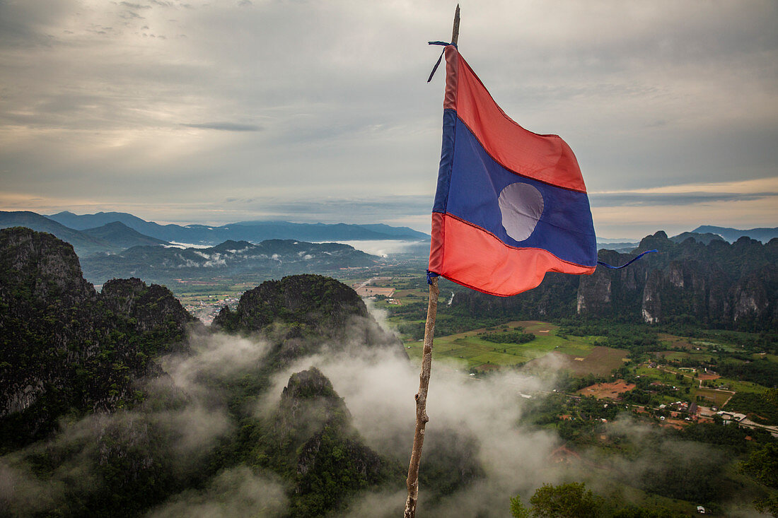 Laos-Flagge mit Aussicht auf Karstlandschaft von Vang Vieng, Laos, Asien