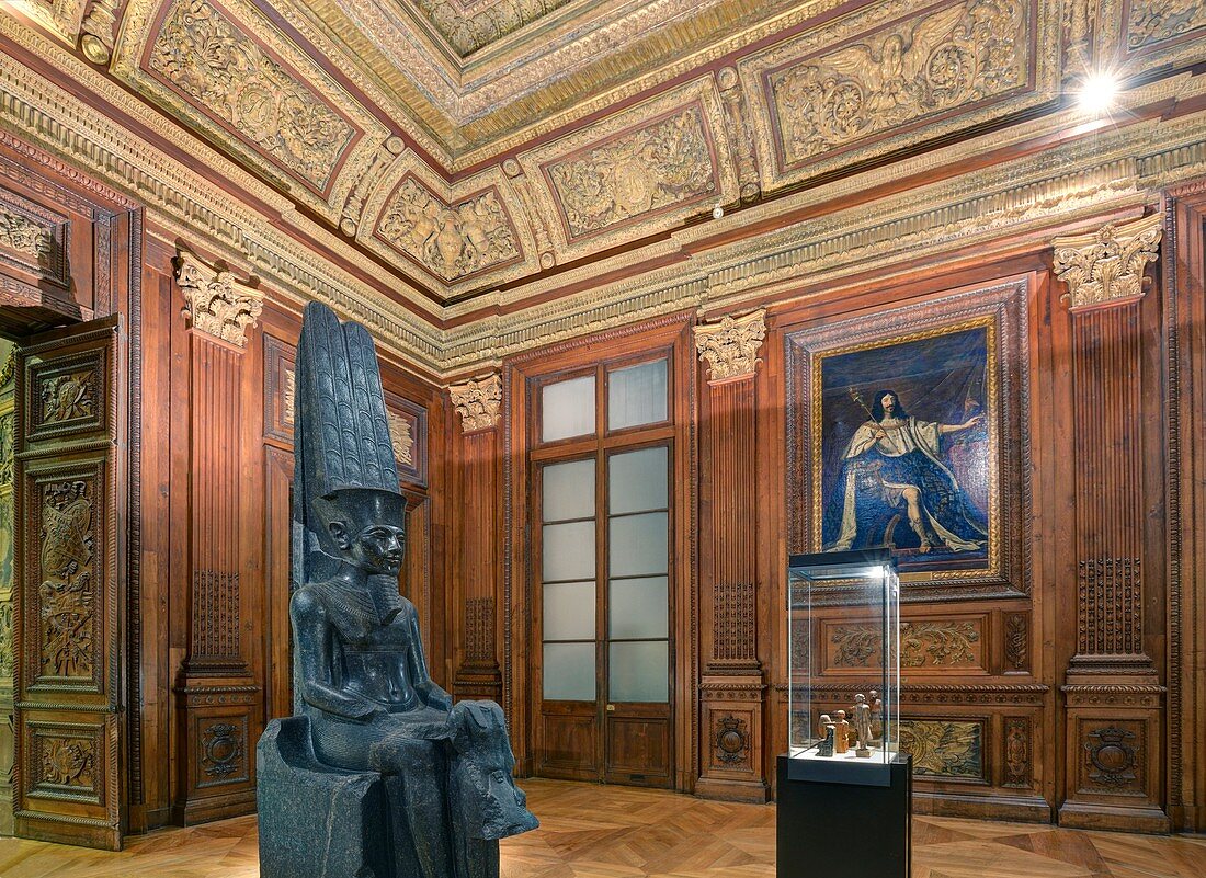 France, Paris, area listed as World Heritage by UNESCO, Louvre museum, egyptian antiquities department, Vincennes room, wood works of the council room in the Queen pavilion of the Château Neuf of Vincennes built in 1654. Statue of the egyptian god Amon protecting king Tutankhamun carved between 1336 an 1327 B.C. and portrait of Louis XIII by Philippe de Champaigne