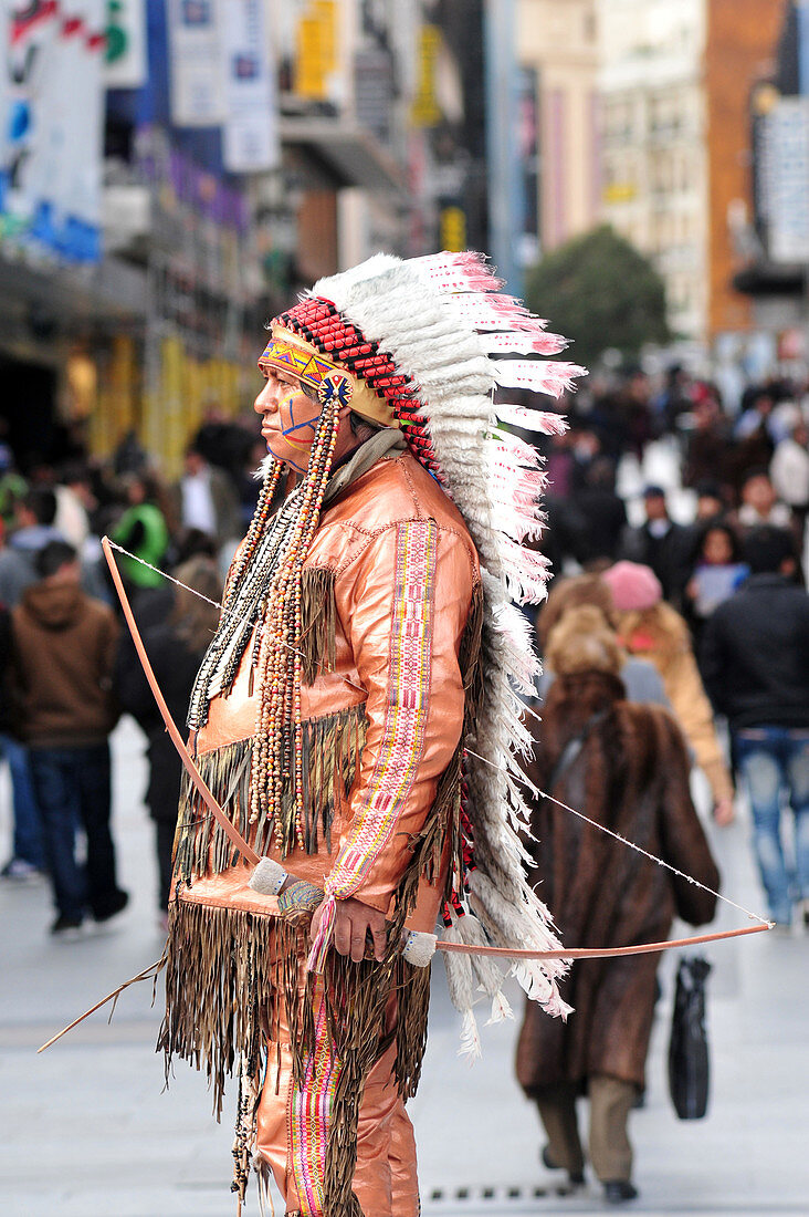 MADRID - MARCH 01 2010:Native American Indian living statue standing  against Spanish pedestrians at Puerta del Sol street, one of the the most busiest places in Madrid.