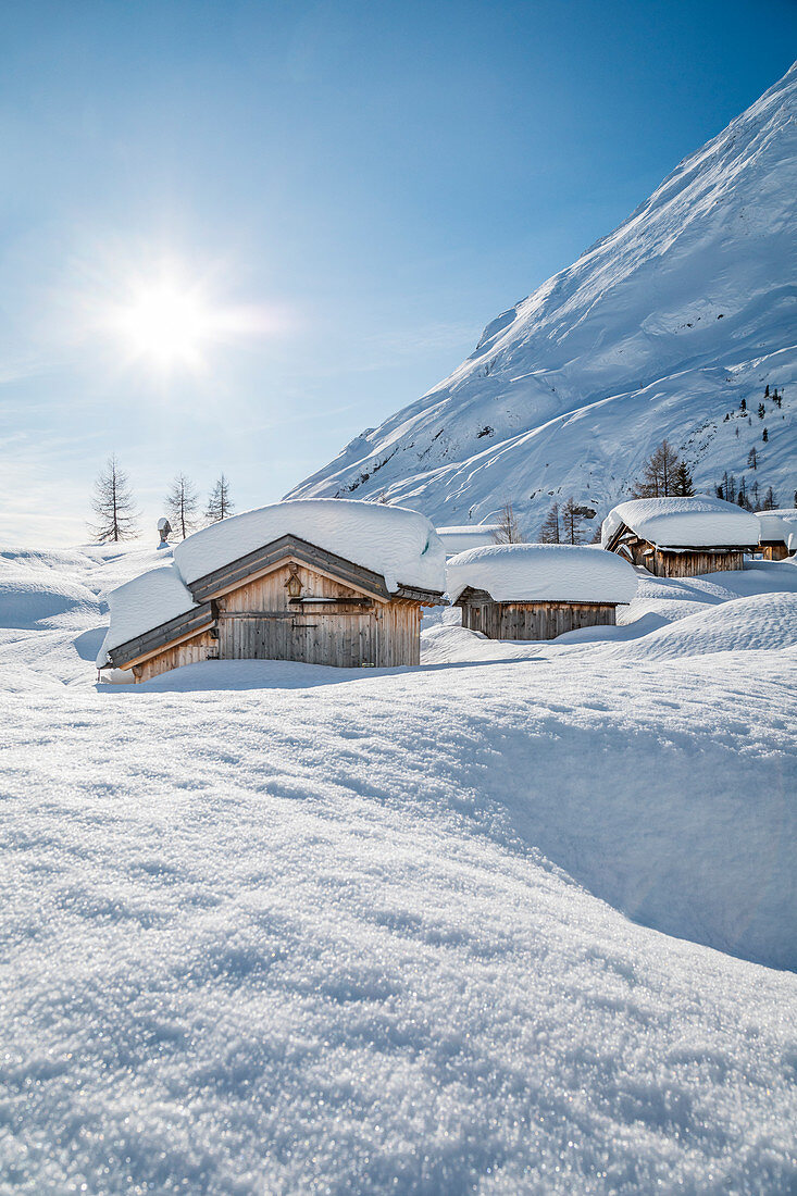 Landschaft der schneebedeckten Berghütten in der Ortschaft Ciamp de Lobia, Fedaia-Pass, Rocca Pietore, Marmolada, Dolomiten, Belluno, Venetien, Italien