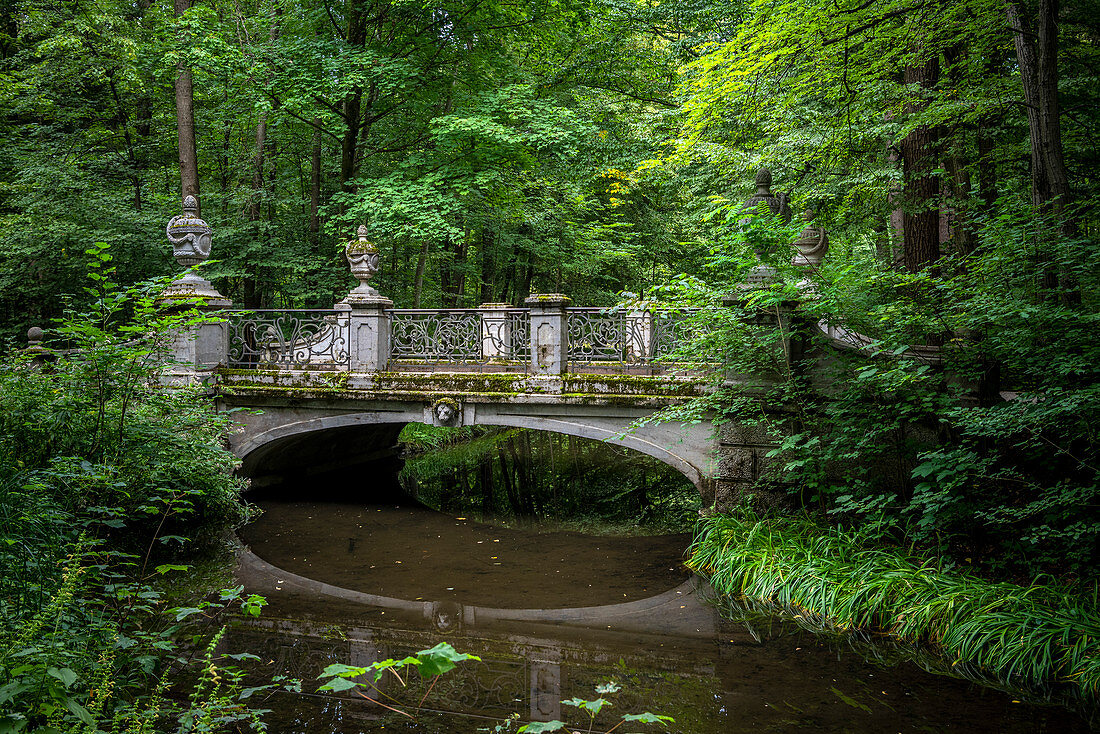 München, Bayern, Deutschland. Brücke über einen Kanal in den Gärten des Schlosses Nymphenburg