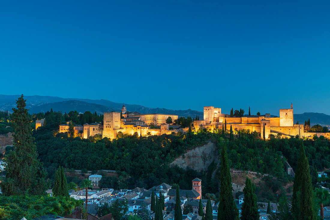Beleuchteter Alhambra-Palast und Festungskomplex in der Abenddämmerung, Granada, Andalusien, Spanien