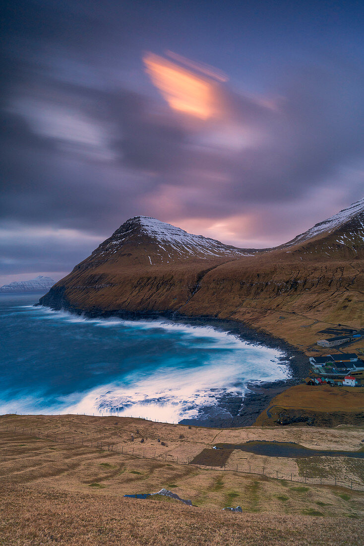 Cloudy sky at sunset over the coastal village of Gjogv, Eysturoy island, Faroe Islands, Denmark