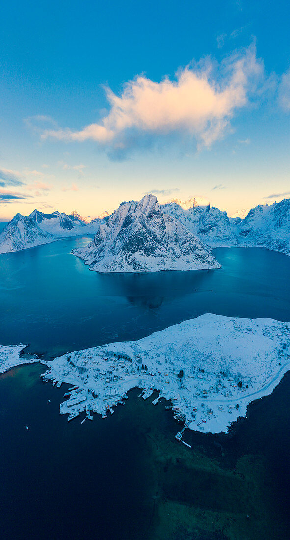 Aerial panoramic of snowy mountains and fjord at dawn, Reine, Nordland, Lofoten Islands, Norway