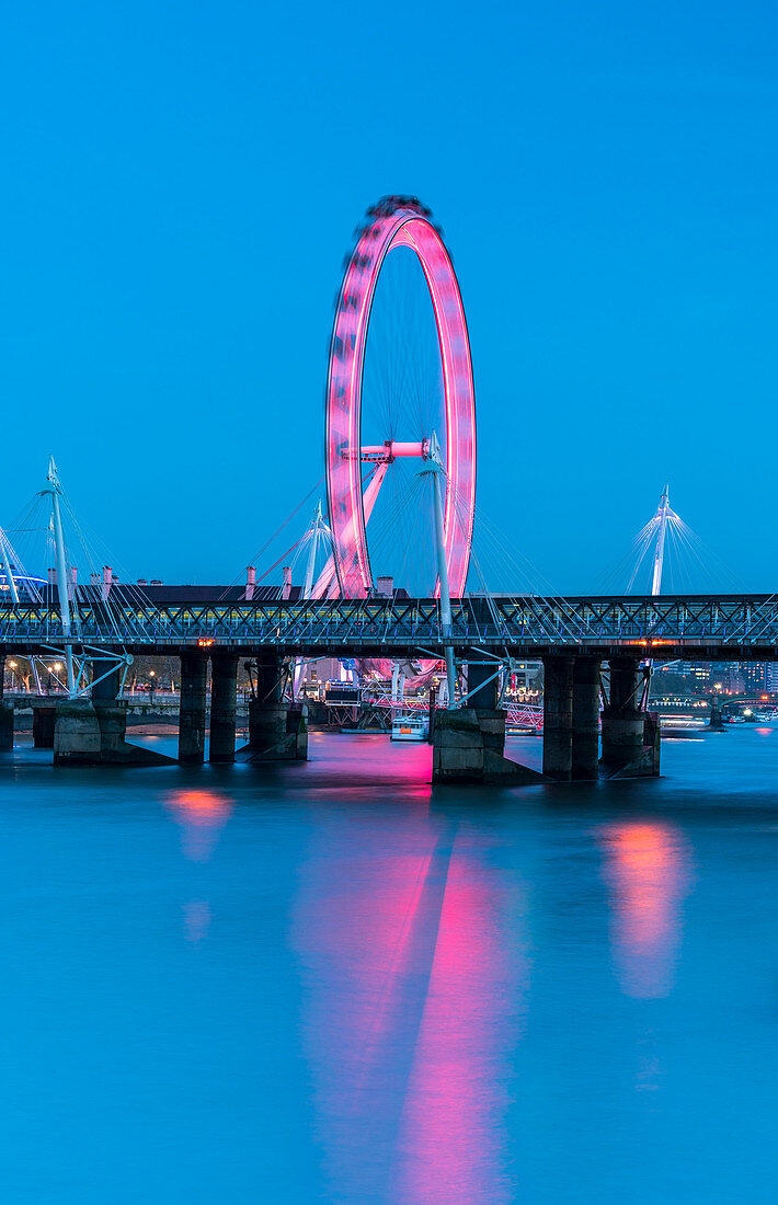 Illuminated London Eye reflected in river Thames at dusk, London, United Kingdom
