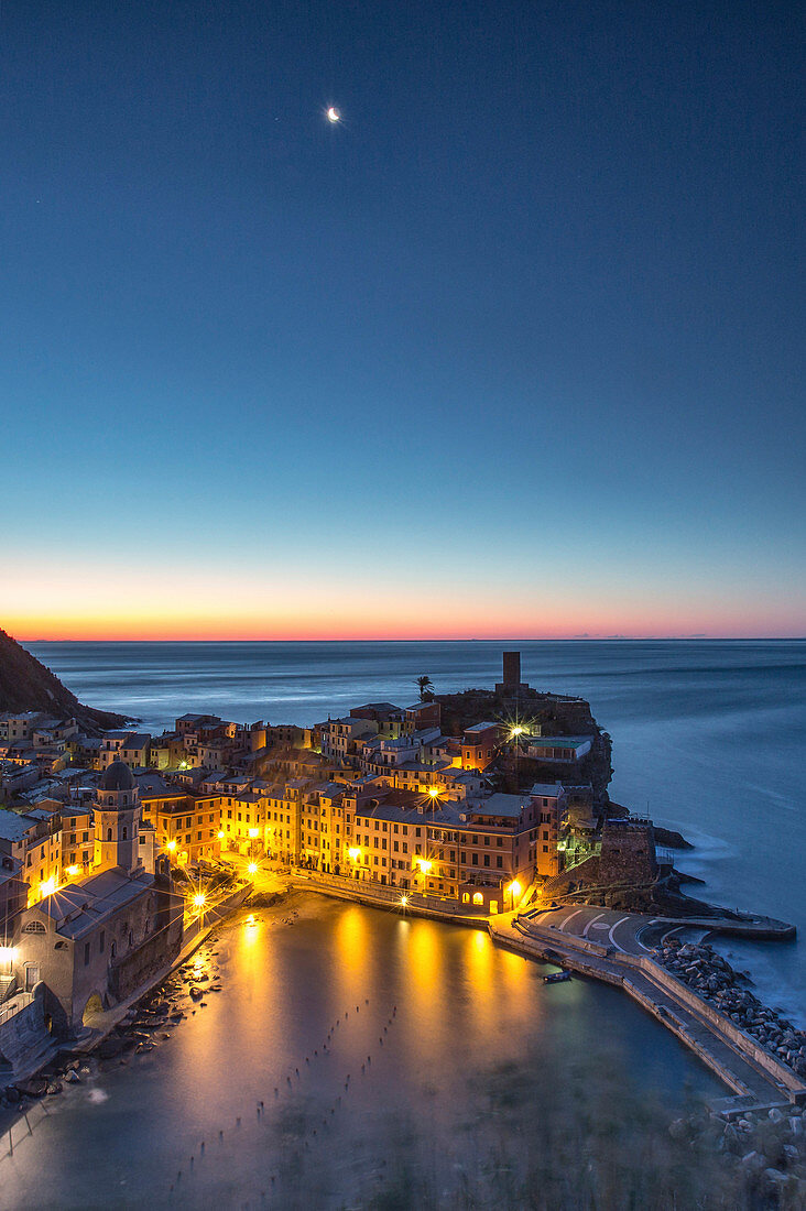 Eine Mondnacht, die die Szene den ersten Lichtern des Sonnenaufgangs über dem malerischen Dorf Vernazza und seinem Hafen überlässt. Dieses Foto wurde von einem Aussichtspunkt entlang des Pfades der Liebe - Cinque Terre National ParK, Ligurien, Italien Europa aufgenommen