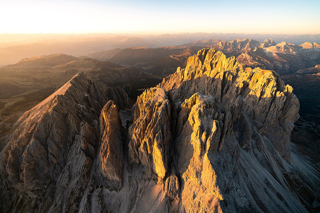 Aerial view of Sassolungo and Sassopiatto at sunset in autumn, Val Gardena, Val di Fassa, Dolomites, South Tyrol, Italy