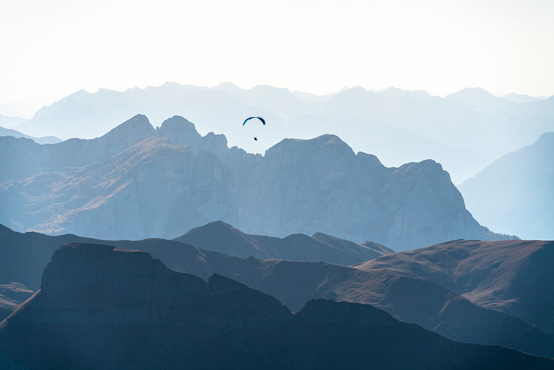 Paragliding bei Sonnenuntergang über Val di Fassa im Herbst von Sass Pordoi, Dolomiten, Trentino, Italien gesehen