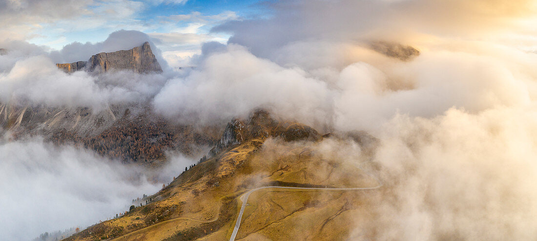Sunset over Giau Pass in a sea of clouds during autumn, aerial view, Dolomites, Belluno province, Veneto, Italy