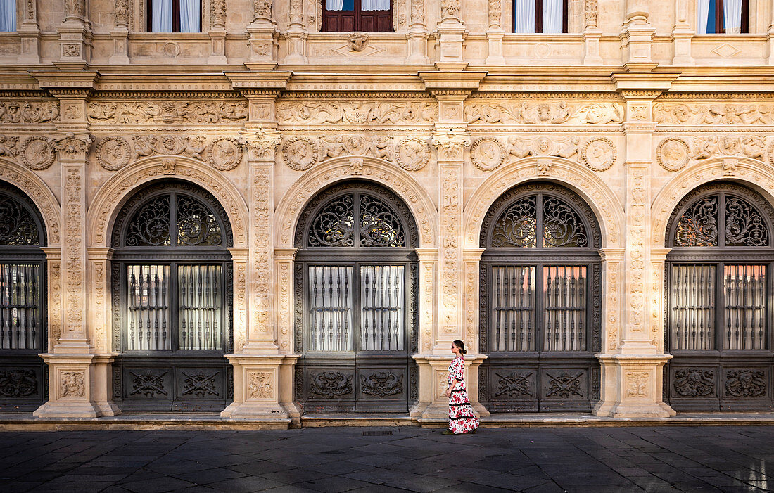Ein Mädchen in einem typischen spanischen Kleid, das in Sevilla, Andalusien, Spanien geht