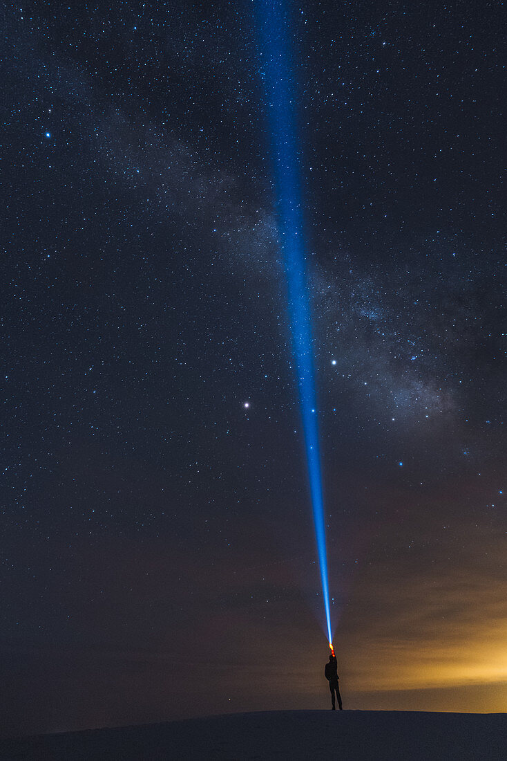 Mann leuchtet mit Fackel in den Himmel, White Sands National Monument, New Mexico, USA