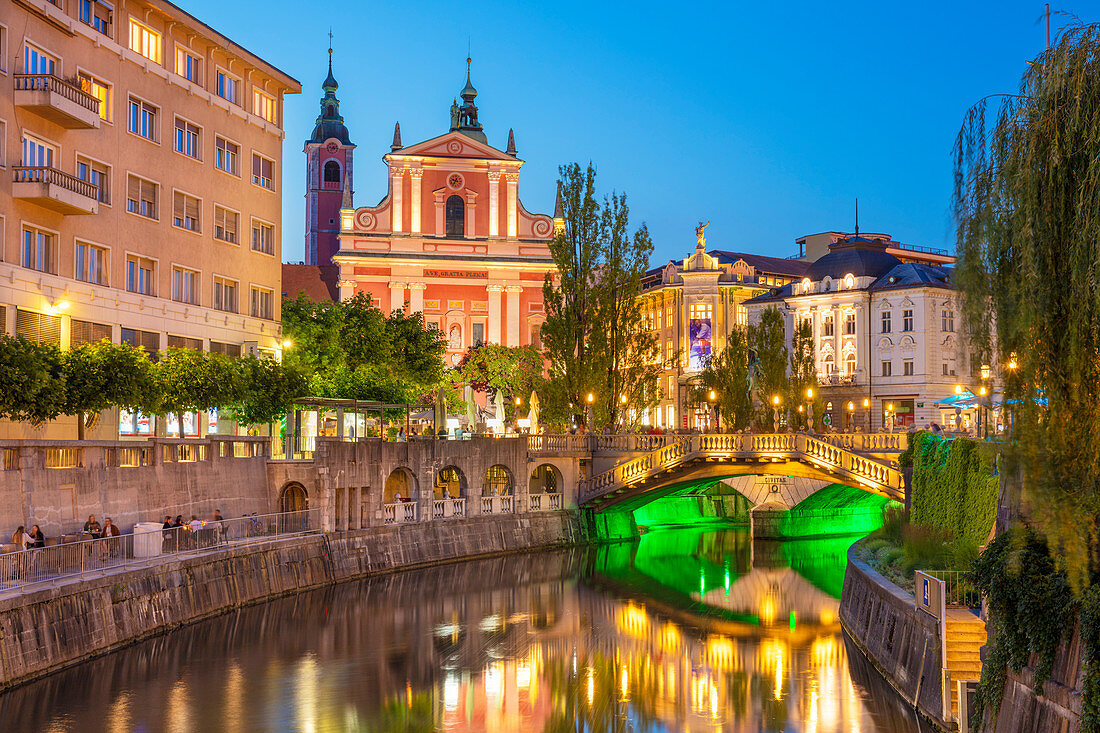 Die rosa Franziskanerkirche der Verkündigung, der Fluss Ljubljanica und die Dreifachbrücke bei Nacht, Ljubljana, Slowenien, Europa