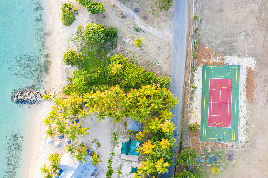 Aerial by drone of Sport court beside a tropical sand beach from above, Morris Bay, Old Road, Antigua, Antigua and Barbuda, Leeward Islands, West Indies, Caribbean, Central America