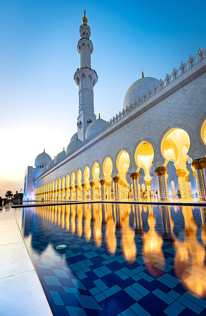 Abu Dhabis prächtige Große Moschee leuchtete während der abendlichen blauen Stunde in Abu Dhabi, Vereinigte Arabische Emirate, Naher Osten