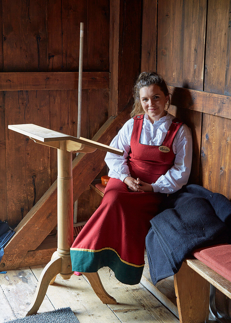 Young woman in traditional costume in the Ringebu Stave Church, Stavkyrkje Ringebu, Ringebu, Gudbrandsdalen, Rondanevegen, Oppland, Norway, Europe