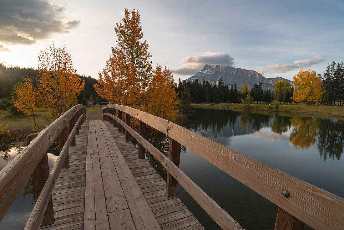 Brücke über Kaskadenteich mit Mount Rundle am Horizont im Herbst, Banff-Nationalpark, UNESCO-Weltkulturerbe, Alberta, Rocky Mountains, Kanada, Nordamerika