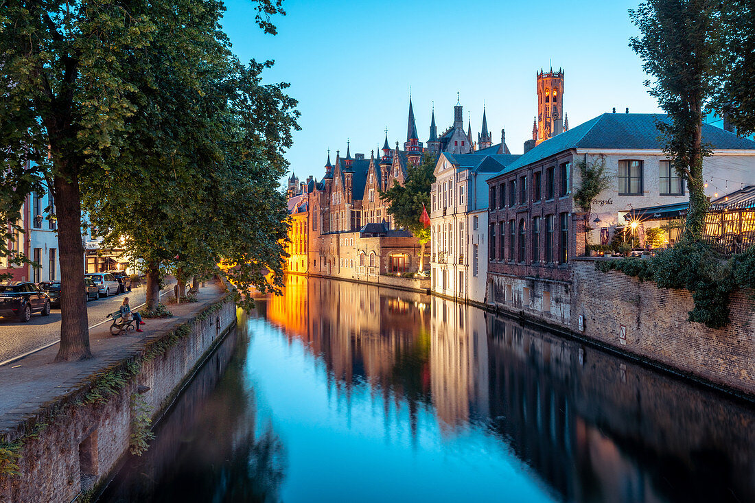 Eine ruhige Kanalszene in Brügge, mit den Türmen des Stadhuis (Rathaus) in der Ferne, Brügge, Belgien, Europa