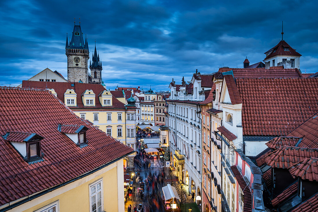 Heading to the Christmas Market in Prague's Old Town Square with the 600 year old Astronomical Clock standing tallest, UNESCO World Heritage Site, Prague, Czech Republic, Europe