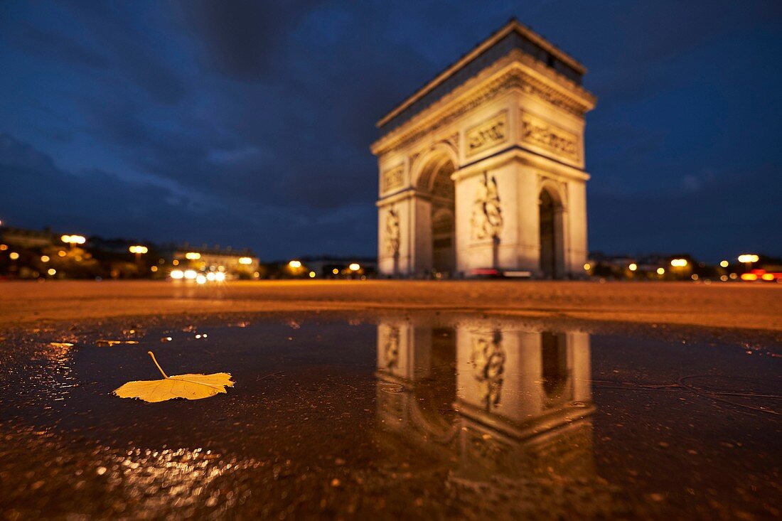 France, Paris, Paris, The Triumph arch reflecting in a pond of water at night