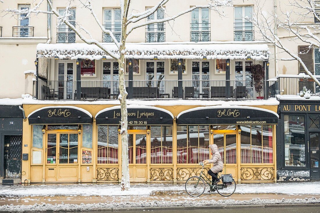 Frankreich, Paris, Gebiet, das von der UNESCO zum Weltkulturerbe erklärt wurde, Quai des Celestins, ein Radfahrer vor dem Restaurant Bel Canto, Schneefall am 07/02/2018