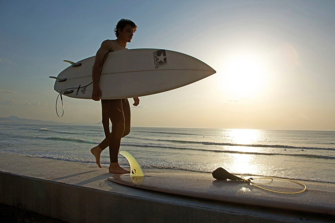 France, Pyrenees Atlantiques, Pays Basque, Biarritz, surfer on sunset in front of the Basques coast beach