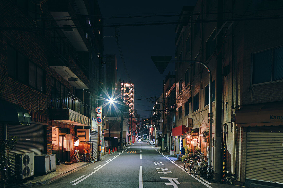 Nachtszene einer leeren Straße und alter Einzelhandels- und Wohnblockgebäude, Osaka, Japan