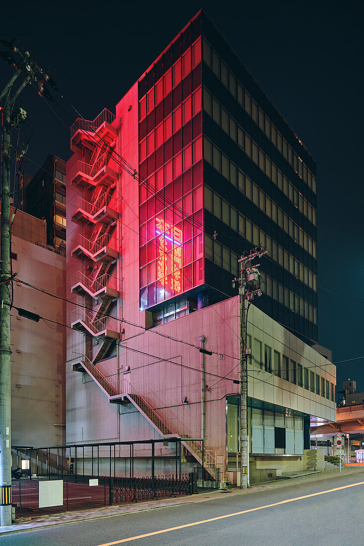 Red light reflected on facade of office building at night,view from the street,Osaka,Japan