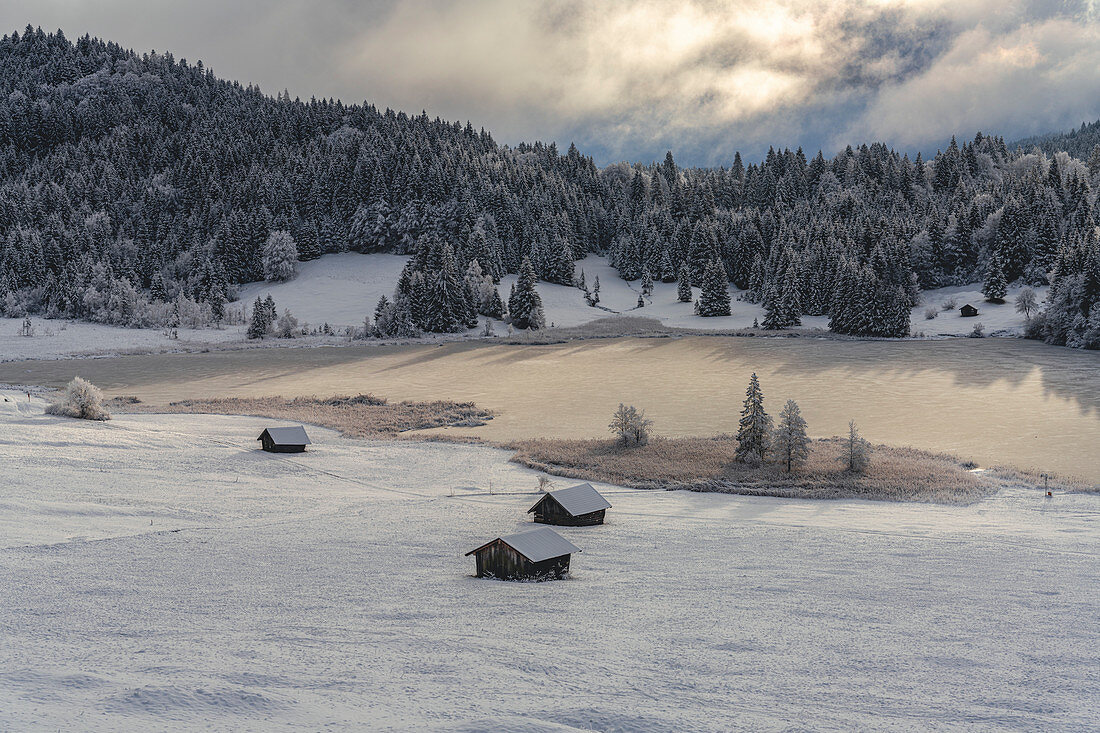 View over the frozen Geroldsee to snow-covered landscape, Krün, Bavaria, Germany.