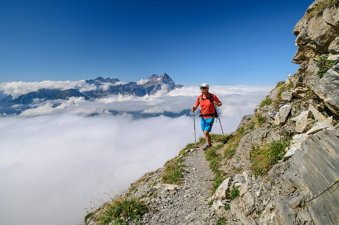 Mann beim Wandern auf ausgesetztem Steig mit Dents du Midi im Hintergrund, vom Dent de Morcles, Berner Alpen, Vaud, Waadtland, Schweiz