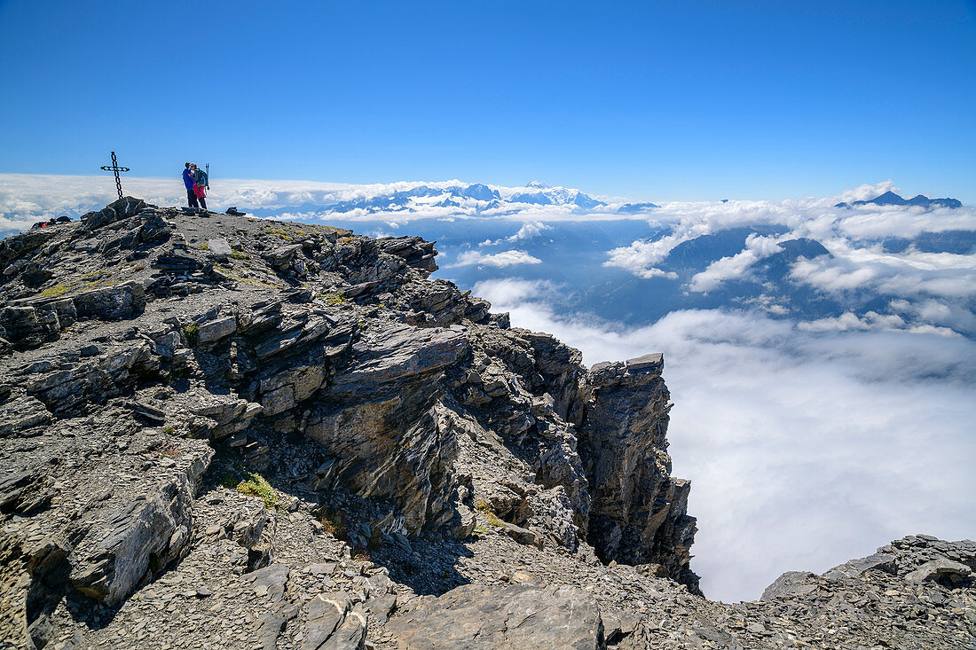 Zwei Personen stehen am Gipfel der Grande Dent de Morcles mit Gipfelkreuz, Mont Blanc im Hintergrund, Dent de Morcles, Berner Alpen, Vaud, Waadtland, Schweiz