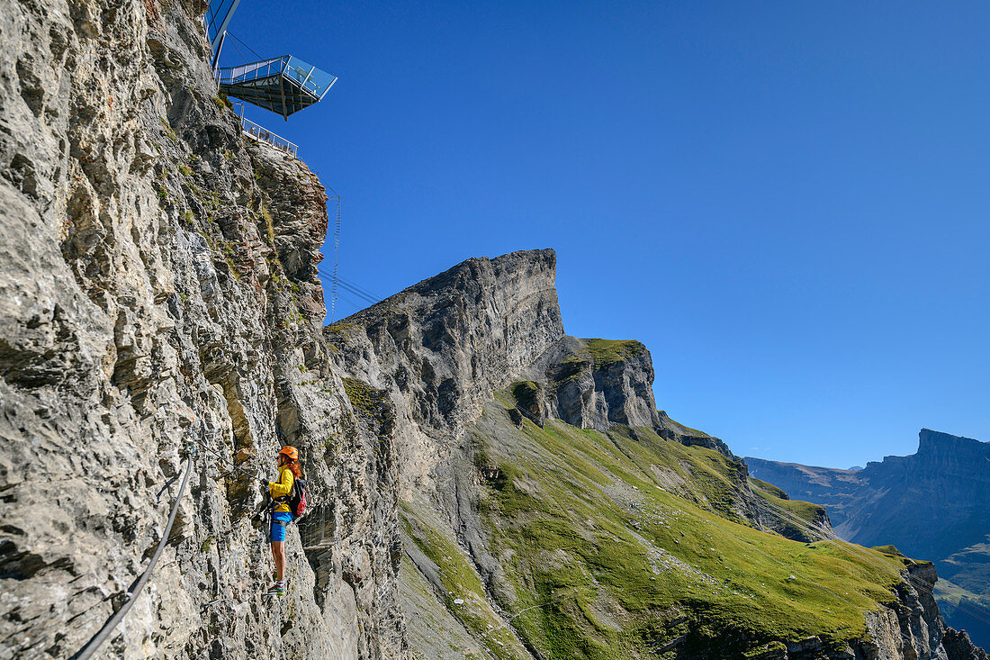 Frau klettert unter Aussichtsplattform am Erlebnisklettersteig Gemmi, Gemmi, Berner Alpen, Wallis, Schweiz