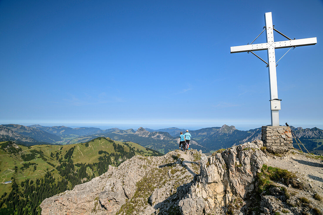 Gipfelkreuz des Litnisschrofen, zwei Personen im Hintergrund blicken auf Tannheimer Berge, Litnisschrofen, Tannheimer Berge, Tirol, Österreich