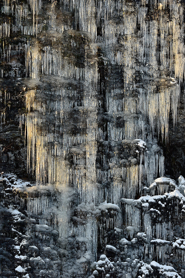 Lange Eiszapfen an einem Felsen im Licht, Nybodarna, Lappland, Schweden